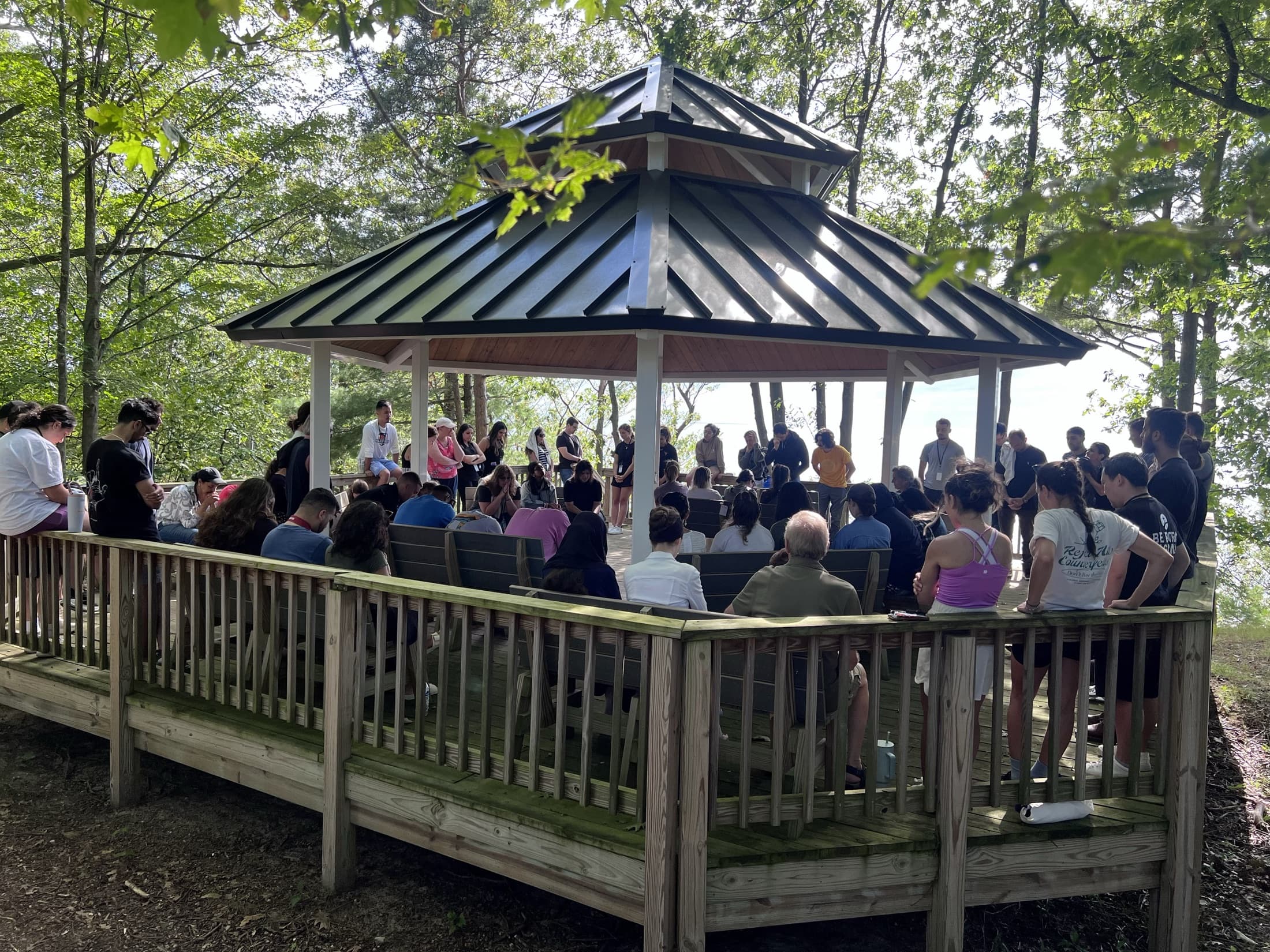 Outdoor prayer gathering in the gazebo overlooking the lake